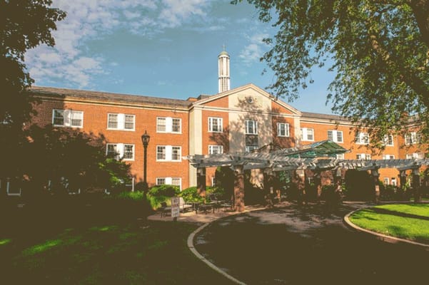 View of the entrance area at Youville Place with greenery and a pergola.
