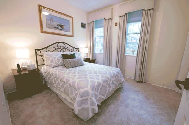 A well-decorated bedroom with a queen-sized bed and natural light