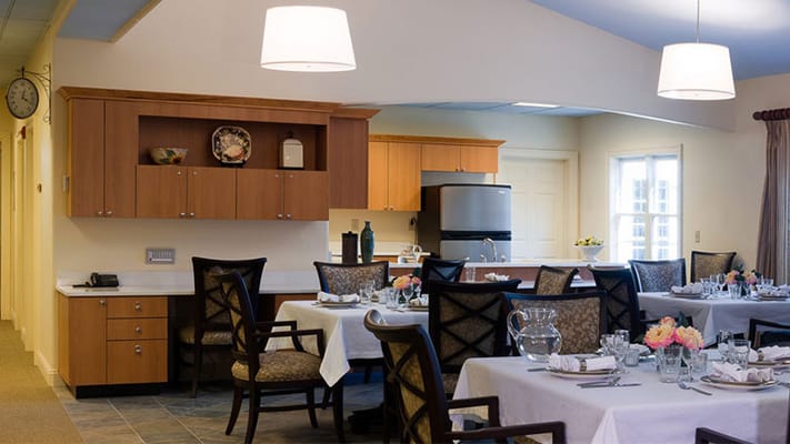Bright dining area set for a meal with tables and chairs