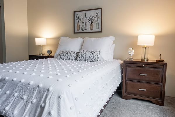 Cozy bedroom setup with decorative pillows and lamps