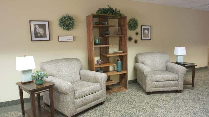 A cozy lounge area with two chairs and decorative shelves