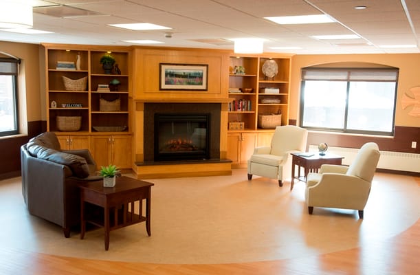 Lounge area with two chairs, a table, and a fireplace.