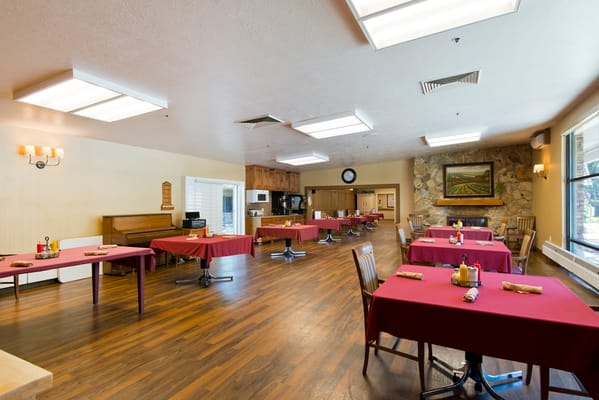 Spacious dining room with red tablecloths and wooden chairs