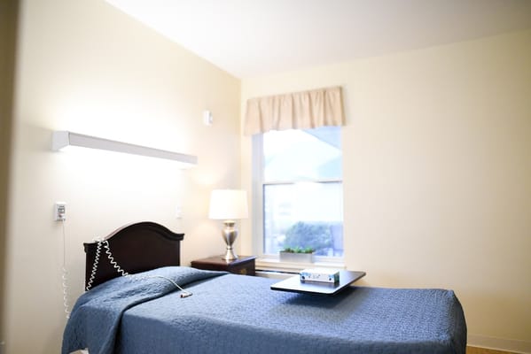 Private resident room with a neatly made bed