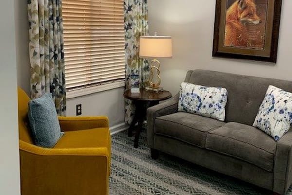 Comfortable lounge area featuring a gray sofa and yellow chair