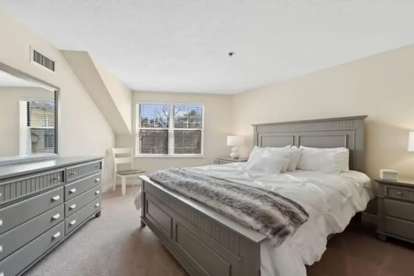 Comfortable bedroom featuring a large bed and modern furnishings.