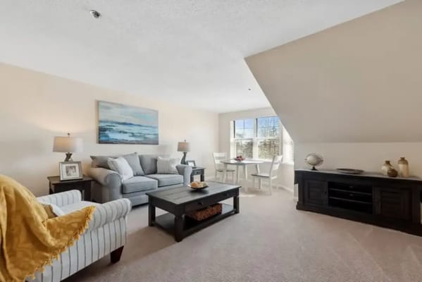 Living room with a sofa, coffee table, and dining area