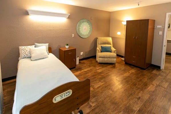 Bright and spacious resident room with a bed and chair