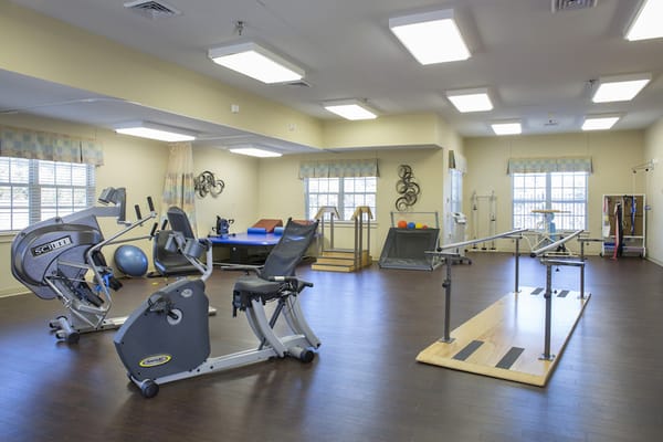 A physical therapy room with exercise equipment and rehabilitation tools.