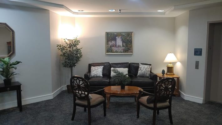 Cozy living area with leather sofa, armchairs, and artwork