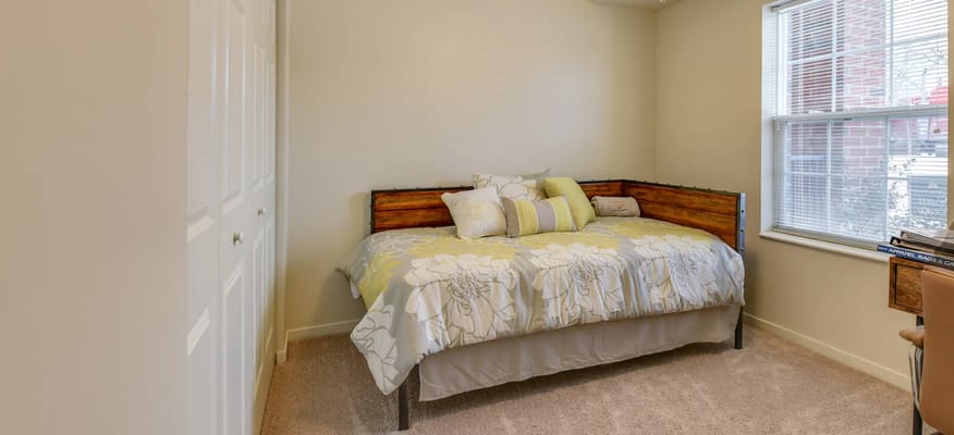 Bright resident room with a cozy bed and pillows