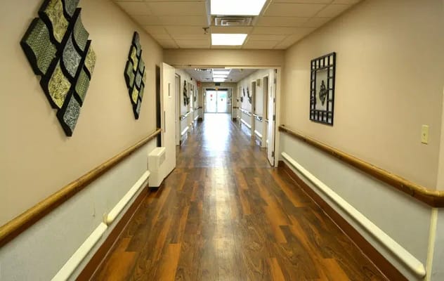 Long hallway with artwork on the walls and wooden flooring