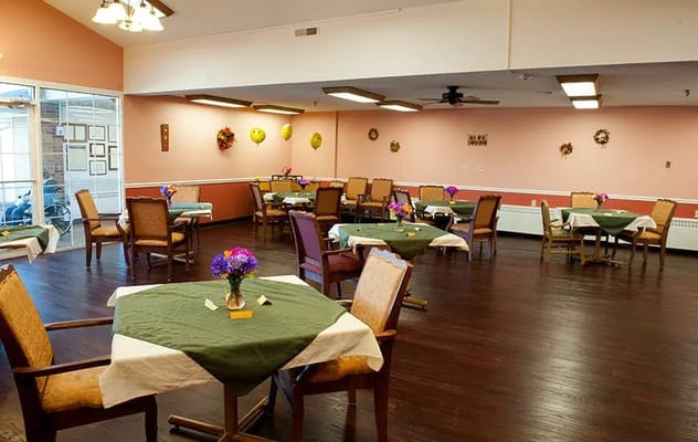 Spacious dining area with green tablecloths and floral centerpieces