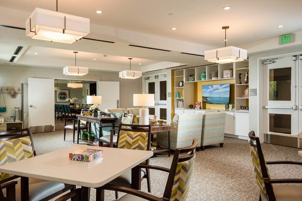 Spacious common area with seating and a TV in Sonnet Hill Senior Living