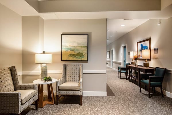 Comfortable seating area with two chairs and a table in the lobby.