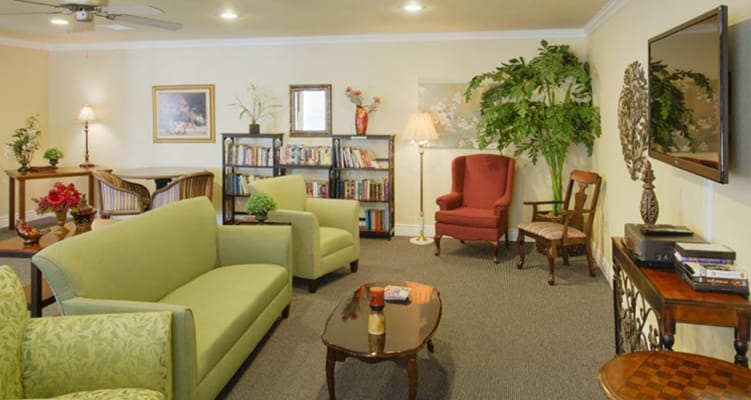 Inviting living room with green sofas and bookshelves