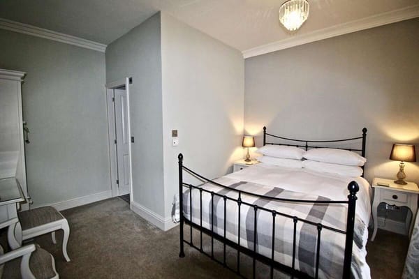 A well-lit bedroom with a double bed and bedside tables.