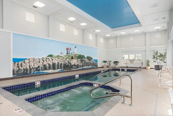 Indoor pool area featuring a mural and spa-like pools.
