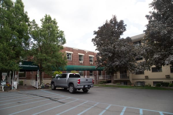 Exterior view of Maplewood Gardens with landscaping and parking area
