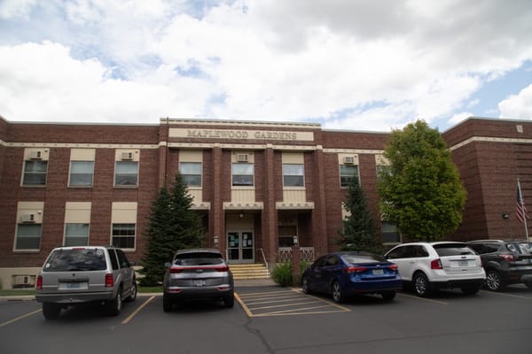 Exterior view of Maplewood Gardens facility with vehicles