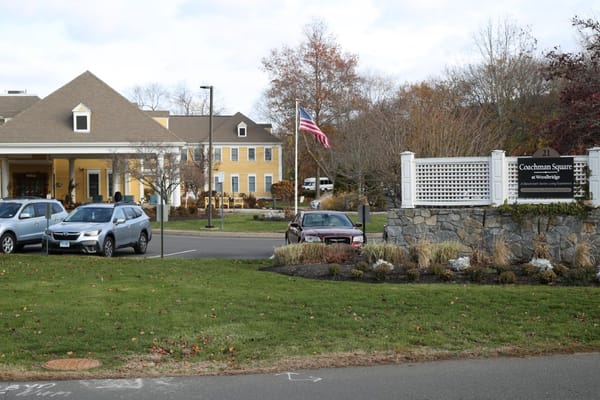 View of the front entrance and signage of Coachman Square at Woodbridge.