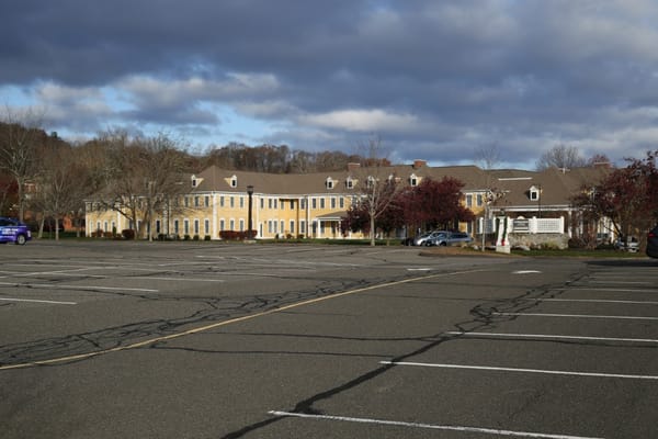 Exterior of Coachman Square at Woodbridge with empty parking lot