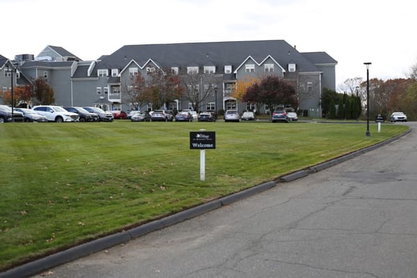 Exterior view of The Village at Mariner's Point with a welcome sign.