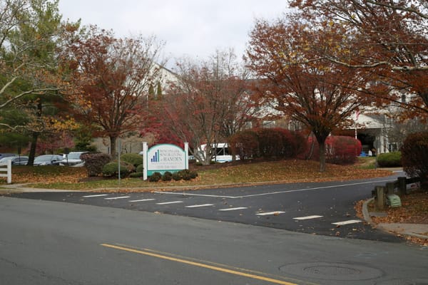 Entrance view of Benchmark Senior Living at Hamden in autumn
