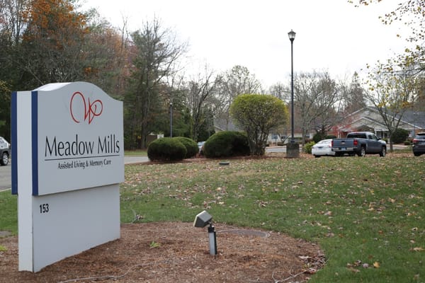 Exterior sign of Meadow Mills Assisted Living facility