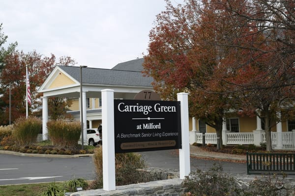 Sign for Carriage Green at Milford with autumn foliage.