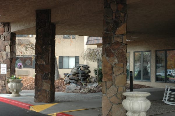 Entrance area with stone pillars and a small water feature