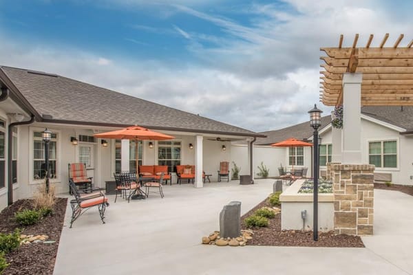 Outdoor seating area with orange umbrellas and landscaping
