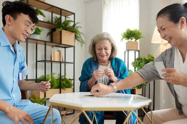 Residents and staff playing cards in a communal area