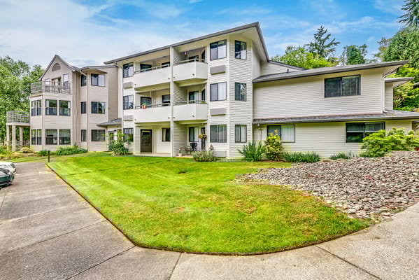 Exterior view of the senior living facility with landscaped grounds
