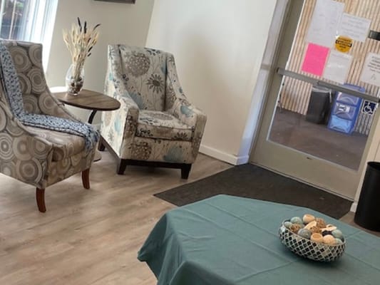 A cozy common area with chairs and a table.