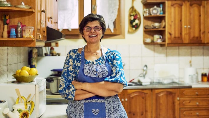 A staff member smiling in a cozy kitchen setting