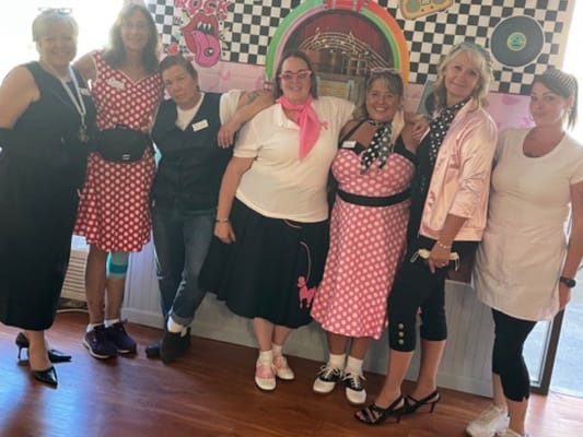 Staff in retro-themed outfits during a celebration