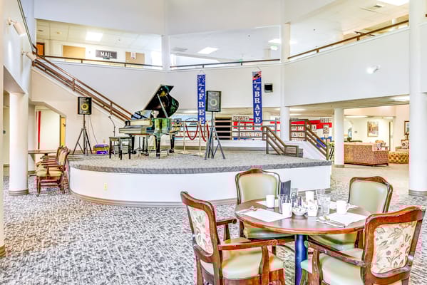 Interior view of a community area with a piano stage