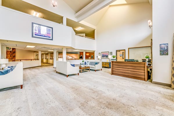 A bright common area with seating and a reception desk