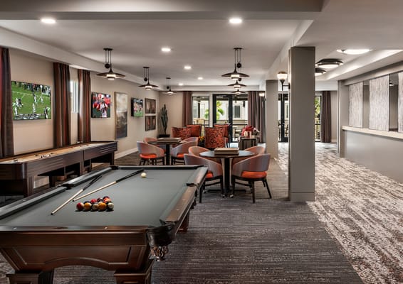 Bright activity room with a pool table and seating