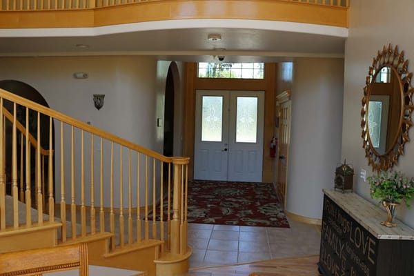 Interior view of a welcoming entrance with wooden staircase