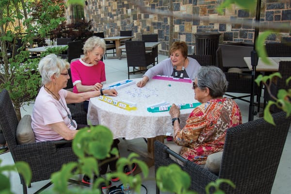 Residents playing a game at an outdoor table