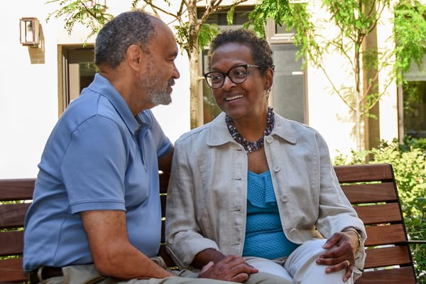 Two residents enjoying company on a bench outside