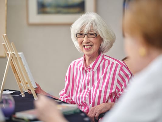Resident participating in an art activity with easels