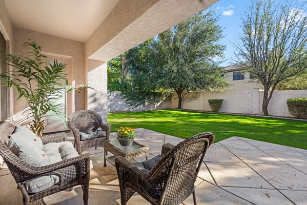 Outdoor seating area with lawn and trees