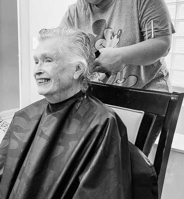 Resident getting a haircut in a facility setting