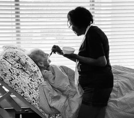 Staff caregiver assisting a resident with a meal