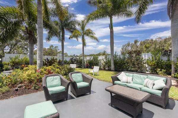 Outdoor seating area with palm trees and garden