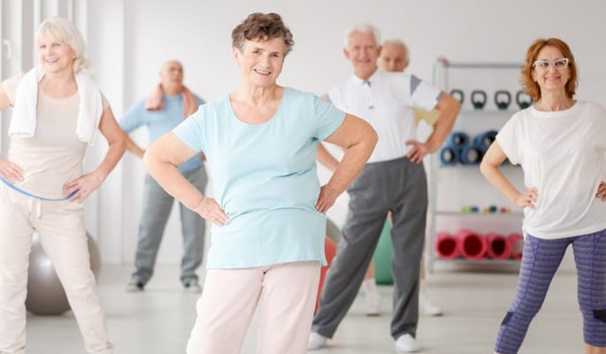 Seniors participating in an exercise class indoors