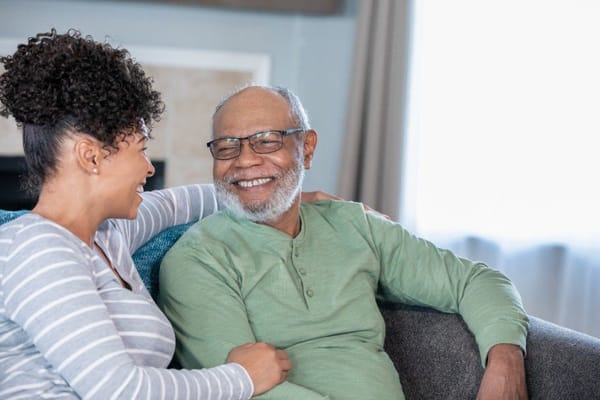 A smiling resident and caregiver sharing a moment together